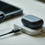 Uma foto mostrando um estojo de fone Bluetooth sendo carregado com um carregador de celular conectado.